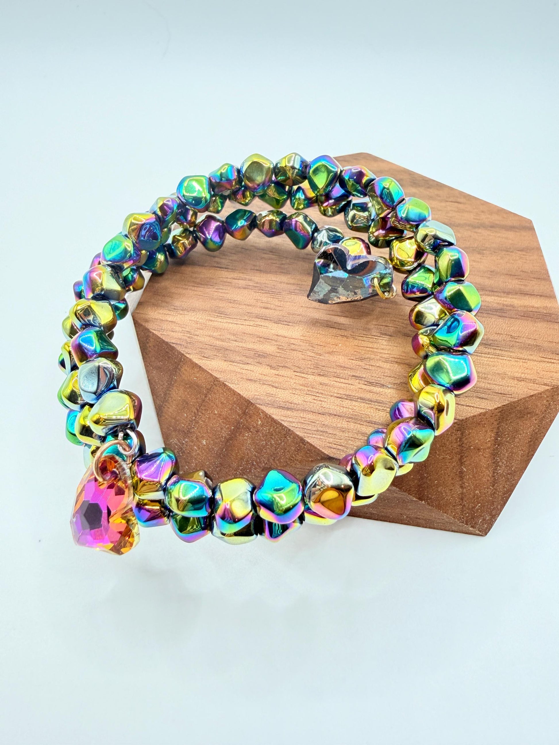 Multicolored beaded bracelet on a wooden block with a white background
