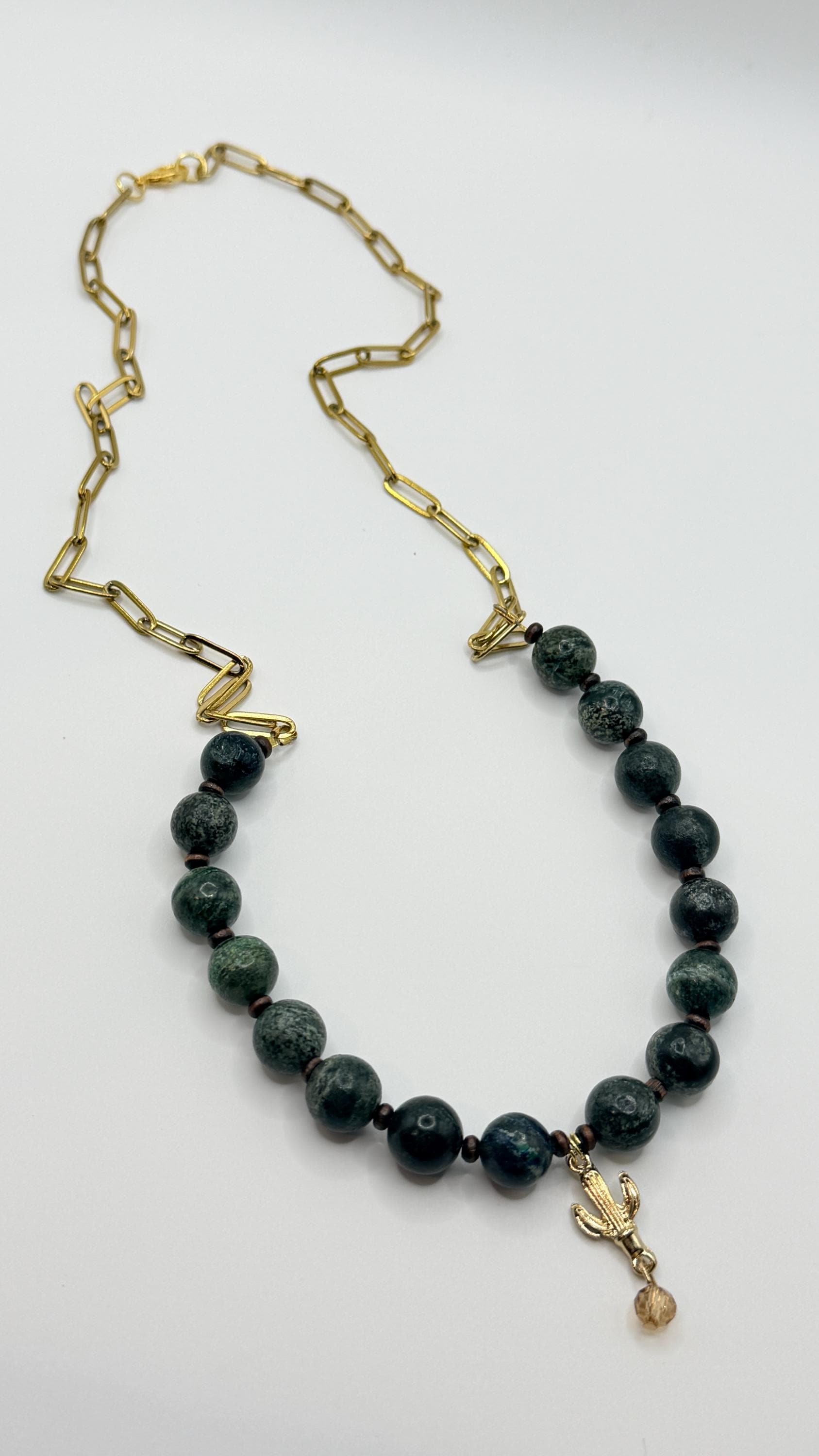 Necklace with black beads and a gold chain on a white background
