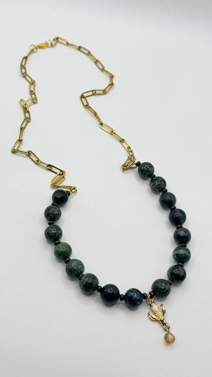 Necklace with black beads and a gold chain on a white background