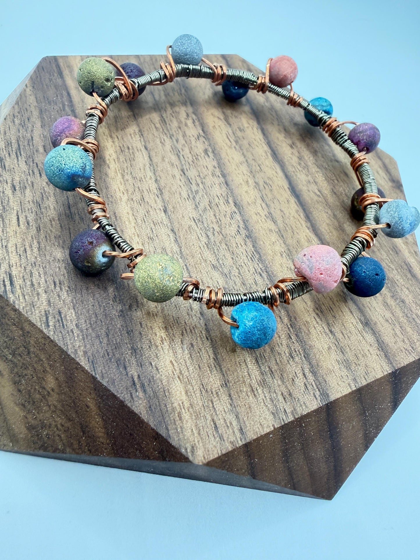 Multicolored beaded bracelet on a wooden block with a blue background