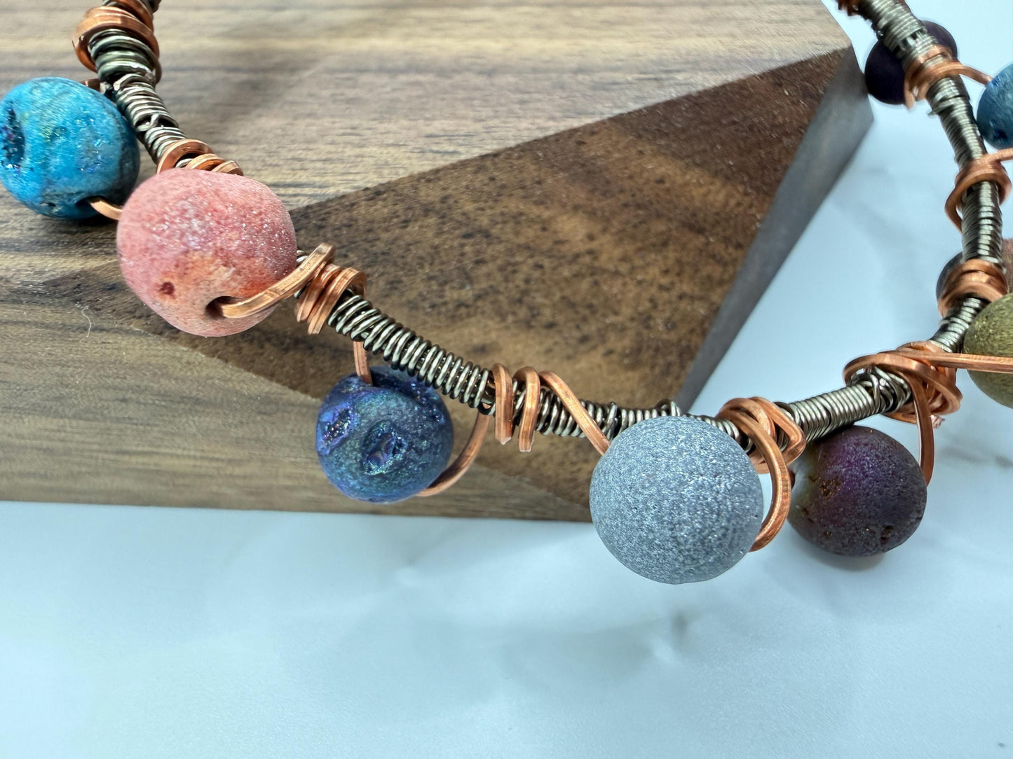 Necklace with colorful beads and wire on a wooden block