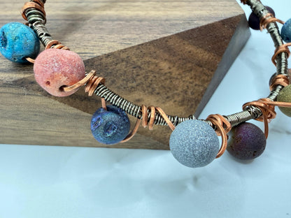 Necklace with colorful beads and wire on a wooden block