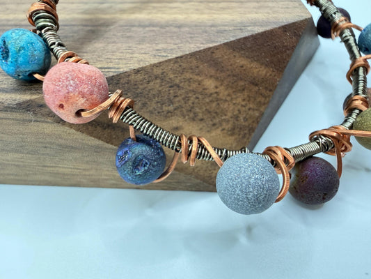 Necklace with colorful beads and wire on a wooden block