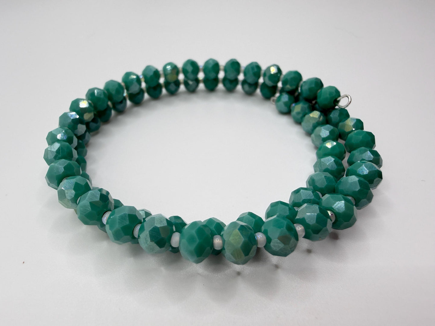 Green beaded necklace on a light gray background