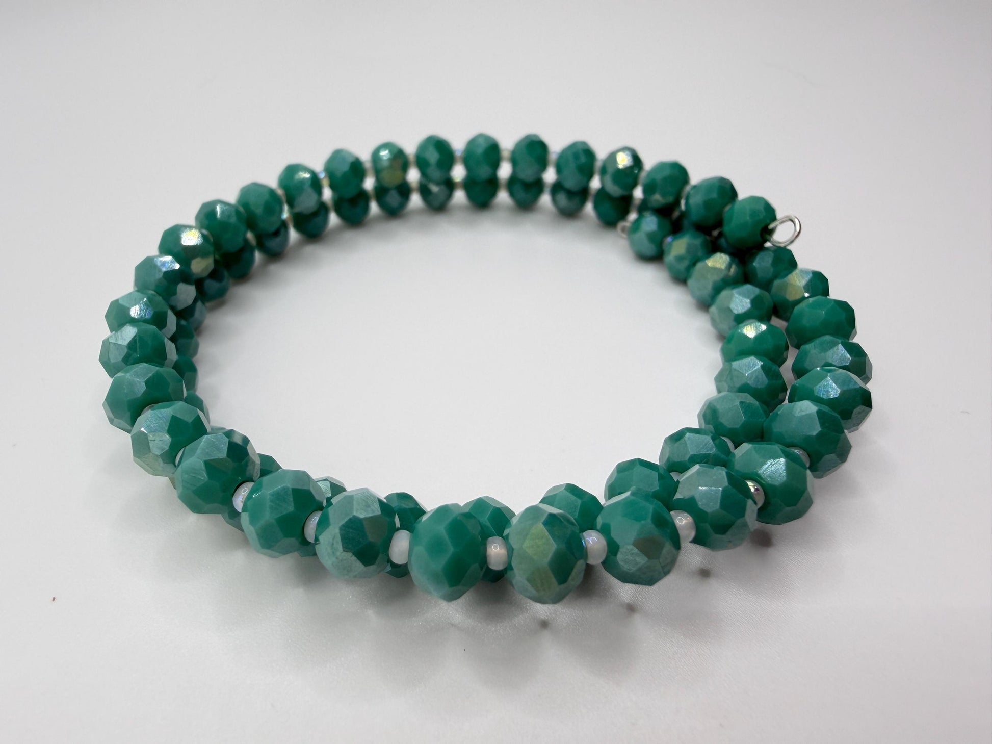 Green beaded necklace on a light gray background