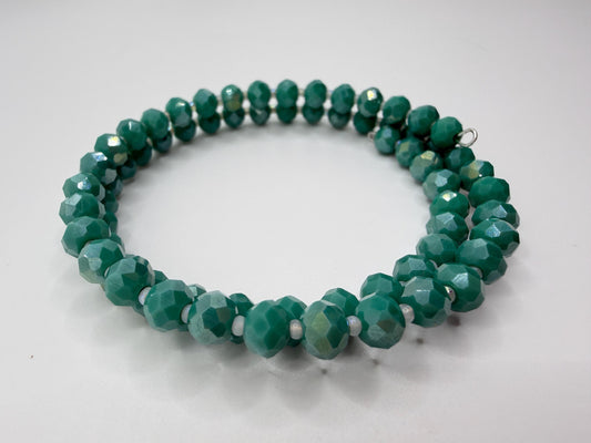 Green beaded necklace on a light gray background