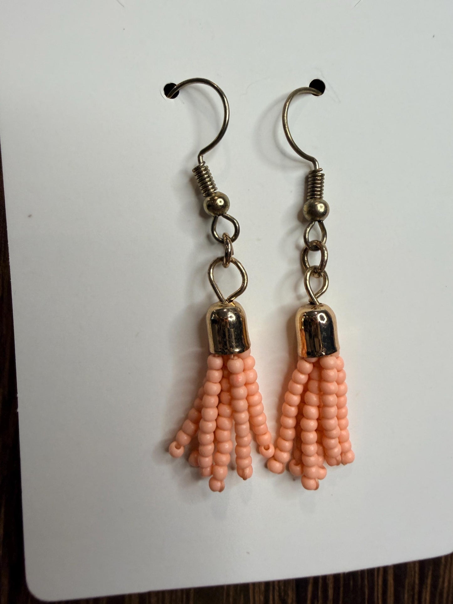 Pair of peach beaded earrings on a white background