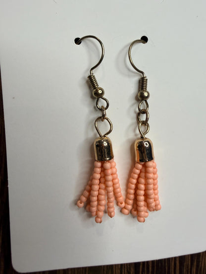 Pair of peach beaded earrings on a white background