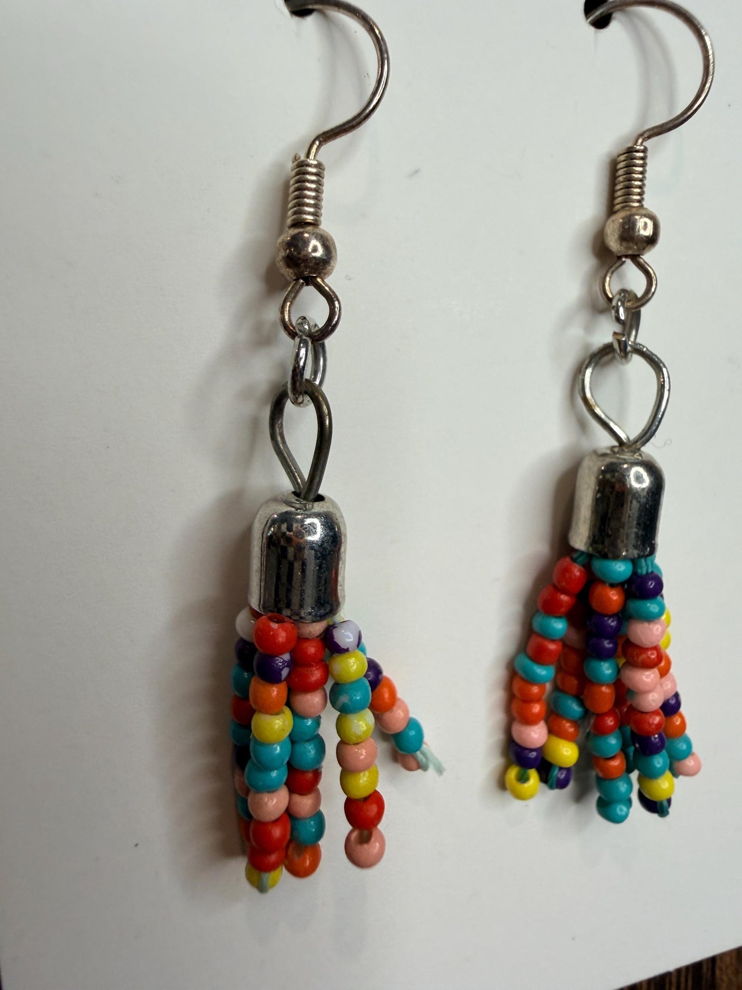 Colorful beaded earrings with silver hooks on a white background