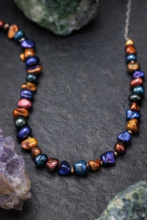 Necklace with multicolored pearls on a dark surface