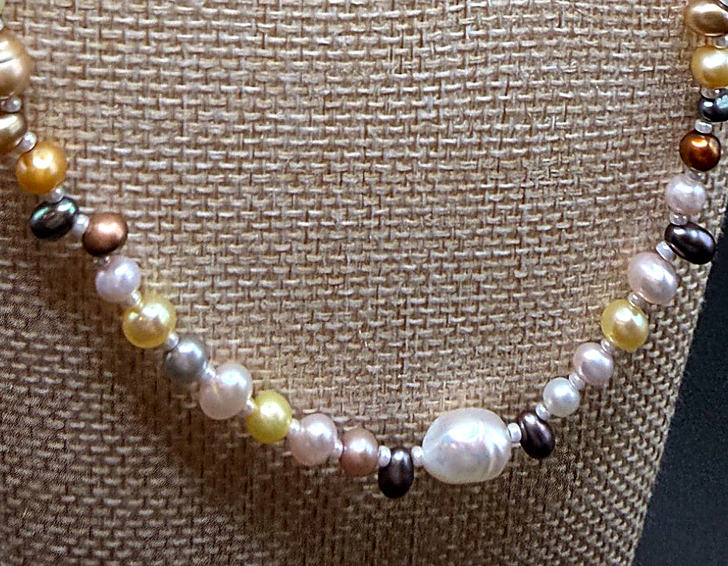 Necklace with multicolored beads on a textured beige background