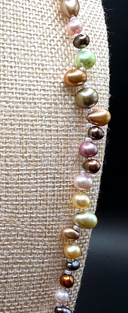 Multicolored pearl necklace on a textured fabric background