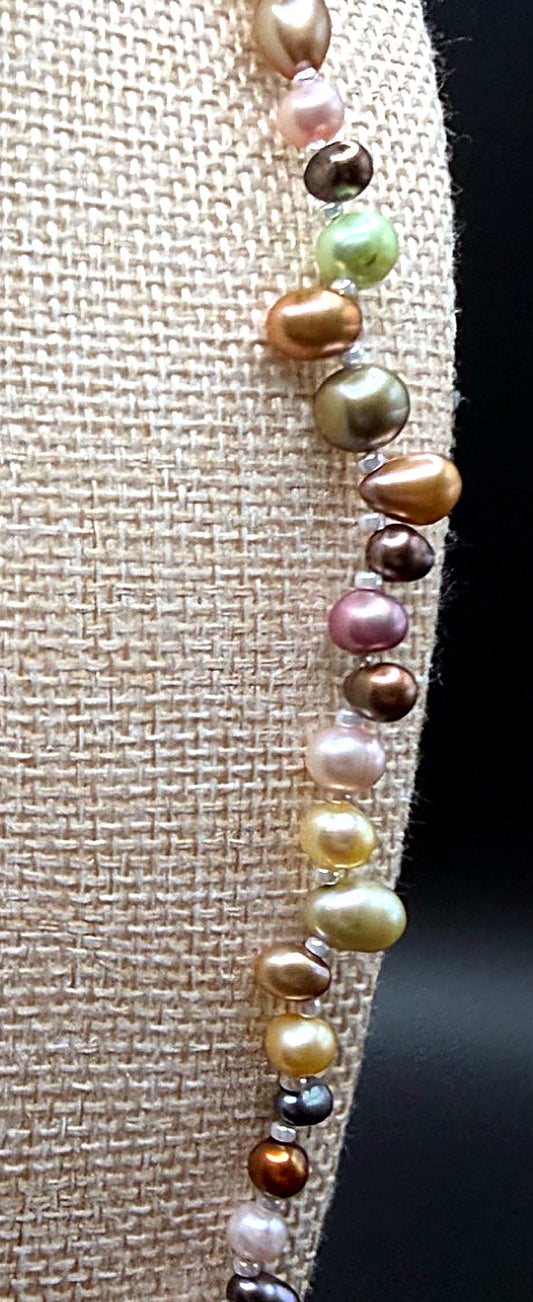 Multicolored pearl necklace on a textured fabric background