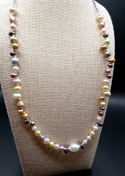 Pearl necklace on a beige bust against a black background