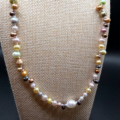 Multicolored pearl necklace on a brown fabric background
